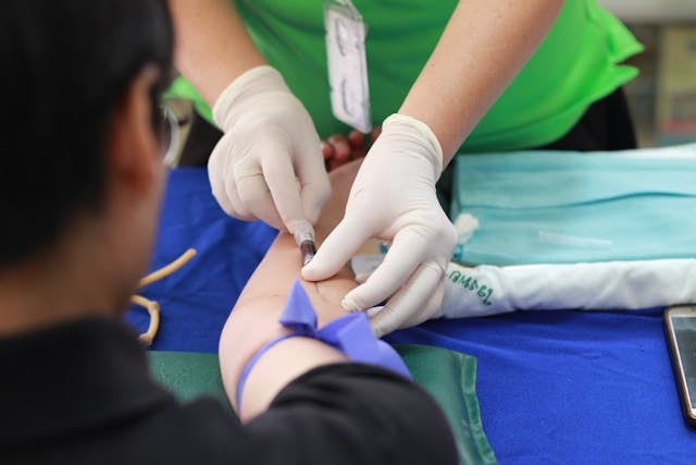 A healthcare injecting something on the arm of a person