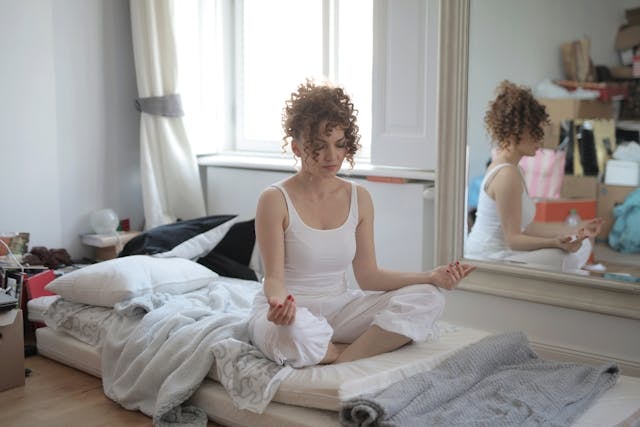 Person on a bed doing a yoga pose