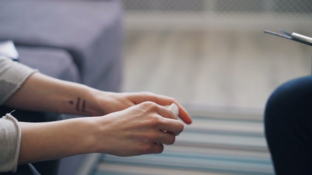 Person's hands in a position that seem that she is listening to someone