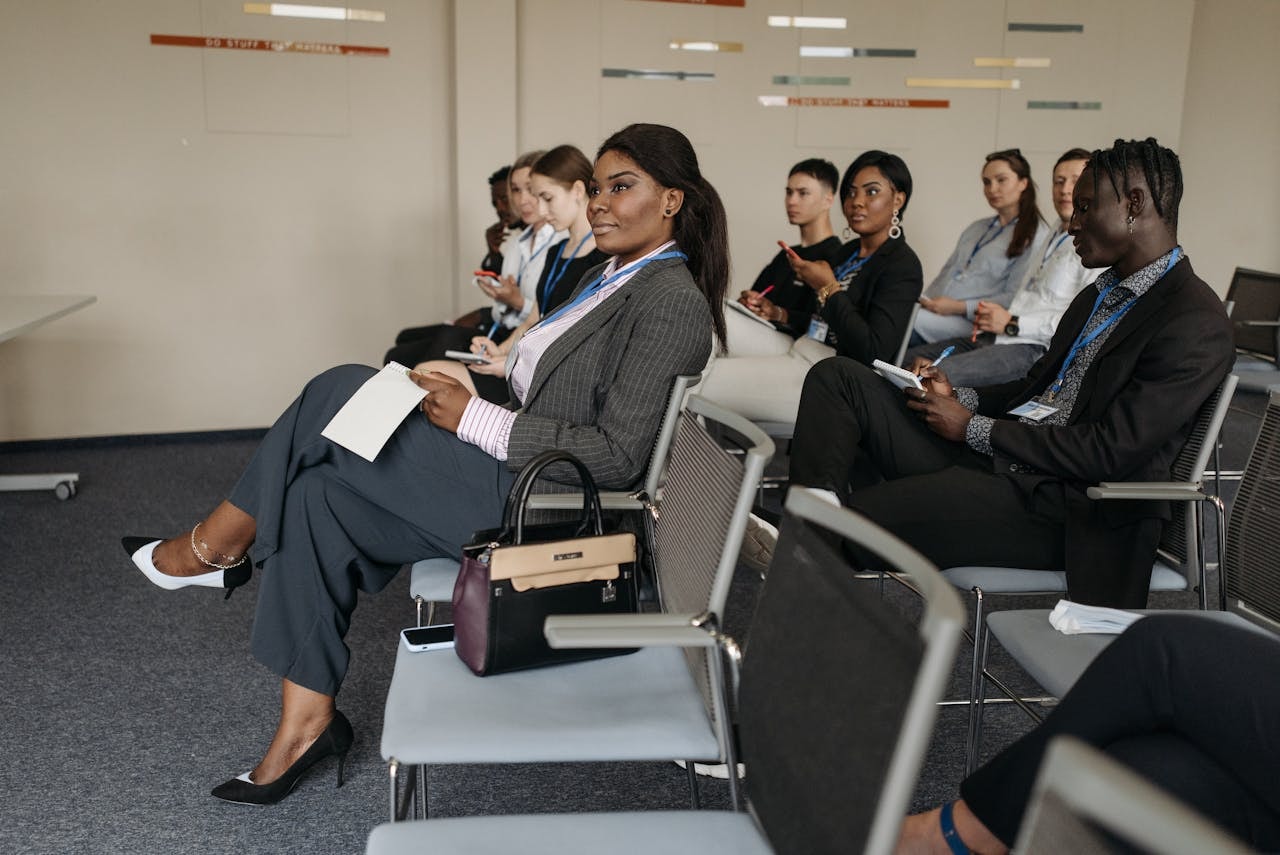 a-group-of-people-sitting-inside-the-conference-room