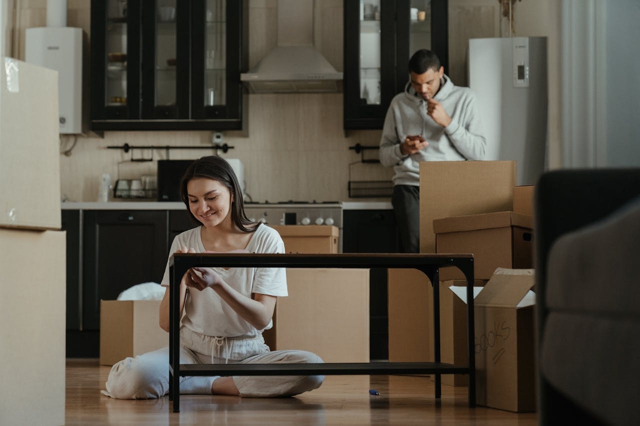 Woman fixing table and man looking at his phone