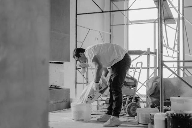 man-in-white-t-shirt-and-black-pants-holding-plastic-bag