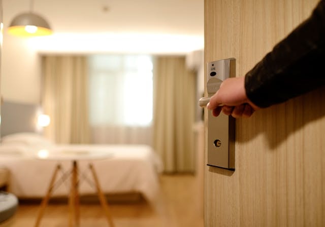 person-holding-on-door-lever-inside-room