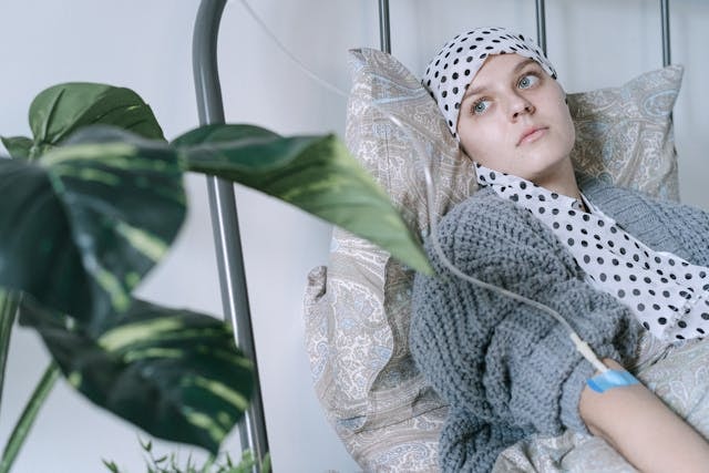 a-woman-wearing-headscarf-having-a-treatment-while-lying-on-hospital-bed