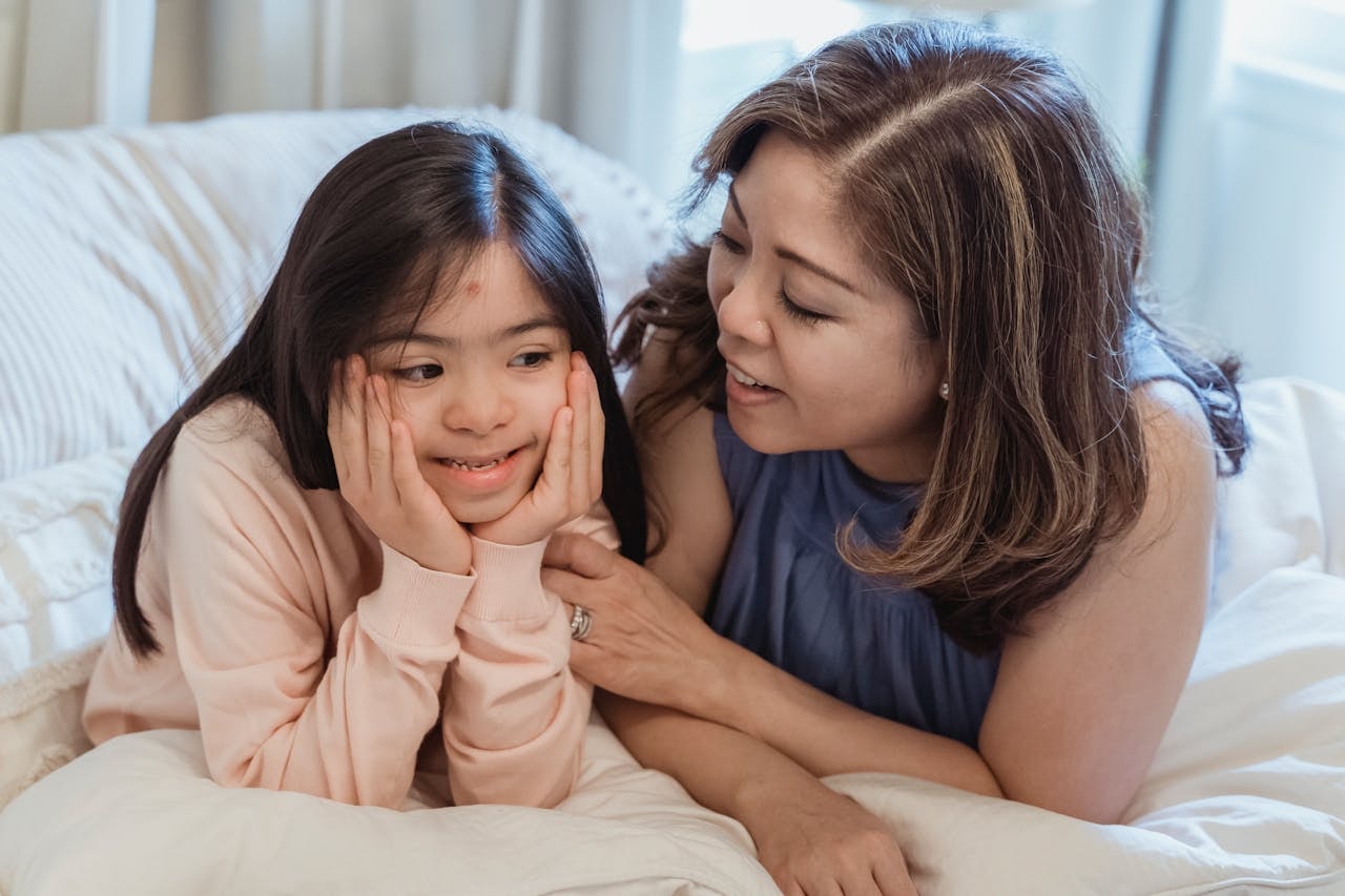 a-woman-and-a-young-girl-sitting-on-the-bed