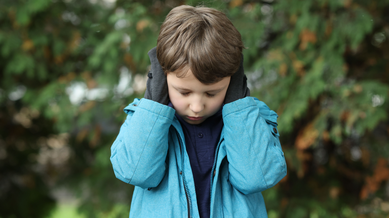 kid covering his ears